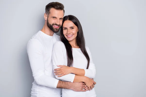 Foto de linda pareja joven abrazar usar camisa blanca aislada sobre fondo de color gris — Foto de Stock