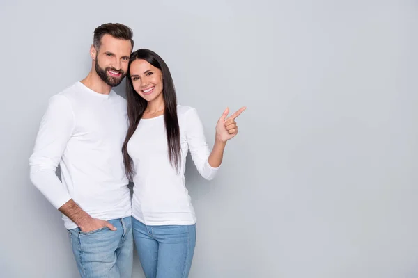 Foto von niedlichen Millennial Paar zeigen Promo tragen weißes Hemd isoliert auf grauem Hintergrund — Stockfoto