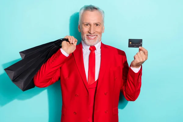 Foto de un jubilado alegre vestido de rojo de tres piezas con gangas de tarjetas de crédito aislado color verde azulado fondo — Foto de Stock
