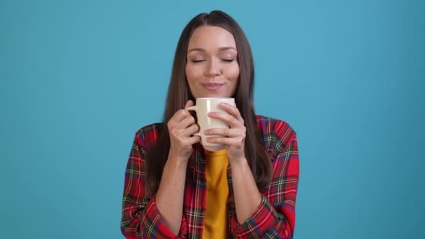 Señora positiva beber cacao caliente fresco aislado fondo de color azul — Vídeo de stock