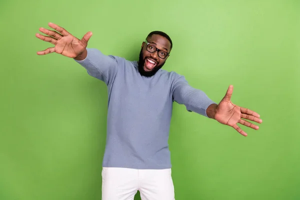 Foto van opgewonden afro guy dragen grijs pullover arm bril open armen wilt knuffel je geïsoleerde groene kleur achtergrond — Stockfoto