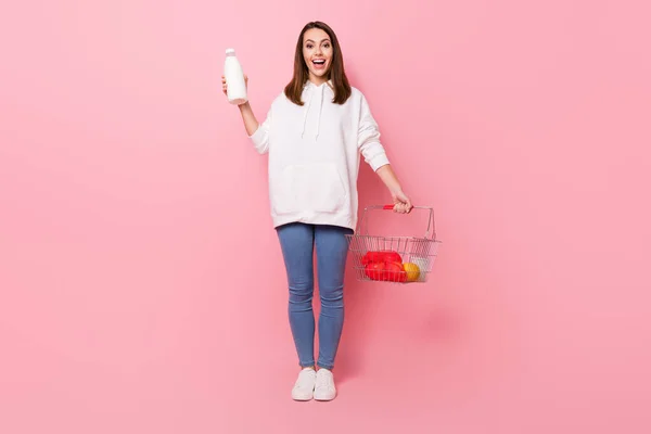 Full length photo of happy nice amazed woman hold hands grocery milk shop isolated on pink color background — Stock Photo, Image