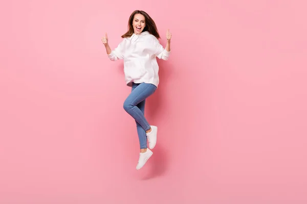 Foto de cuerpo completo de feliz mujer alegre agradable salto aire hacer dedos pulgares hacia arriba aislado sobre fondo de color rosa —  Fotos de Stock