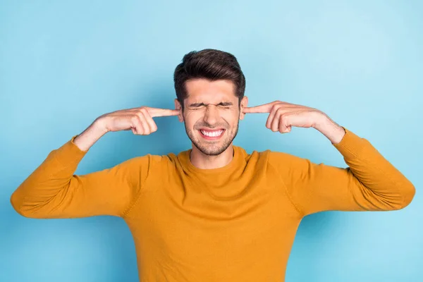 Foto di giovane uomo vicino orecchie dita rumoroso rumore irritato stressato isolato su sfondo di colore blu — Foto Stock