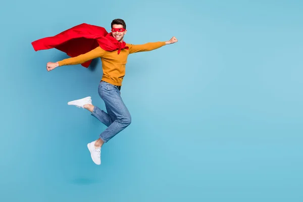 Genç Süpermen 'in tam vücut profilli fotoğrafı mutlu pozitif gülümseme uçuş giysisi maskesi mavi arka planda izole edilmiş. — Stok fotoğraf