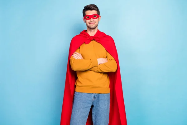 写真の甘い魅力的な若い男の服を着た黄色プルオーバースーパーマンの衣装腕交差笑顔隔離された青の色の背景 — ストック写真