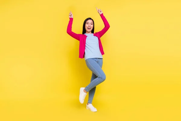 Foto em tamanho completo de impressionado morena jovem senhora dança desgaste rosa camisola jeans isolado no fundo amarelo — Fotografia de Stock