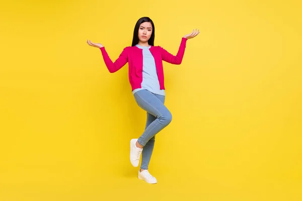 Full body photo of sad brunette millennial lady hold empty space wear pink pull jeans isolated on yellow background — Photo
