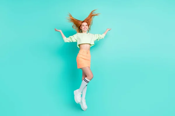 Фотографія повного розміру веселої позитивної молодої жінки, що літає, стрибає у вітер, ізольовані на кольоровому фоні — стокове фото