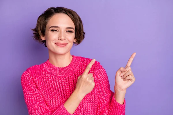 若い女性の幸せな笑顔の写真は指を示す空のスペース広告プロモーションは、紫色の背景に孤立を示唆しています — ストック写真