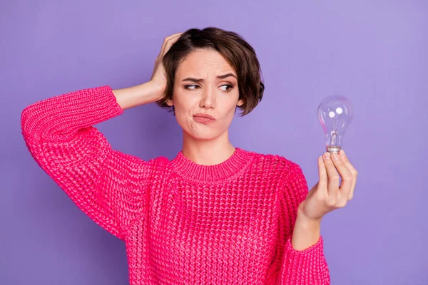 Zdjęcie atrakcyjnej pani wygląd zainteresowany ramię trzymać lampę myśląc nosić sweter izolowany na fioletowym tle koloru — Zdjęcie stockowe