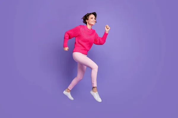 Longitud completa perfil lado de la foto de la joven sonrisa feliz salto ir correr velocidad prisa venta aislado sobre fondo de color violeta —  Fotos de Stock