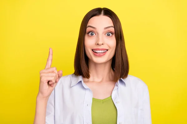 Foto de impressionado morena jovem senhora índice até desgaste camisa azul isolado no fundo de cor amarela — Fotografia de Stock