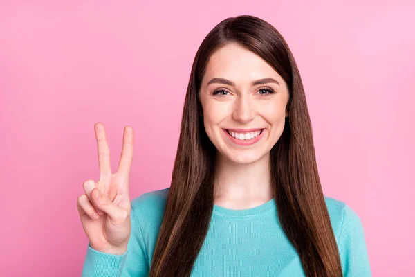 Foto retrato de chica mostrando paz v-signo sonriendo en traje casual aislado sobre fondo de color rosa pastel — Foto de Stock