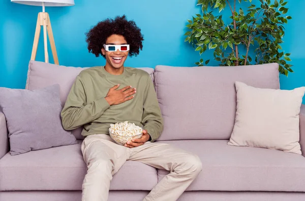 Photo of young guy laughing hand on chest watch comedy humorous eat popcorn isolated over blue color background — Stock Photo, Image