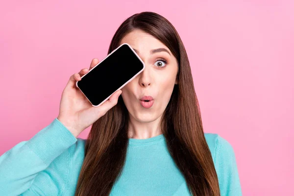 Foto de encantadora mujer joven feliz cubierta ojo de la pantalla del teléfono aislado sobre fondo de color rosa pastel — Foto de Stock