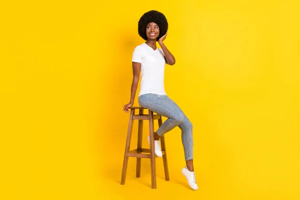 可愛い黒い肌の女性の写真白いTシャツアームヘアドア座ってバーチェア空のスペースを探して隔離された黄色の色の背景 — ストック写真