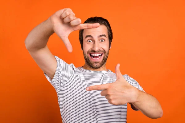 Фото молодого сумасшедшего человека хорошее настроение жест пальцы снимают изображение изолированы на оранжевом фоне цвета — стоковое фото