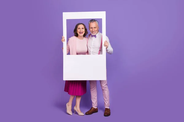 Retrato de longitud completa de socios positivos divertidos sostienen momento de cámara de papel aislado sobre fondo de color violeta — Foto de Stock