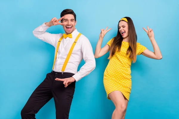 Foto de dos divertidos estudiantes alegres muestran v-signo disfrutar de entretenimiento discoteca aislado sobre fondo de color azul — Foto de Stock