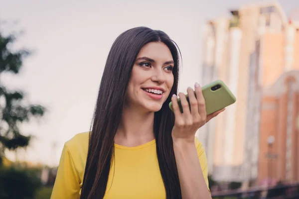 Фото привлекательной веселой леди держать телефон говорить общаться голосовой чат имеют хорошее настроение на улице — стоковое фото