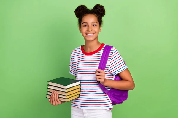 Retrato de menina alegre atraente que volta para a biblioteca livro de retenção da escola isolado sobre fundo de cor verde brilhante — Fotografia de Stock