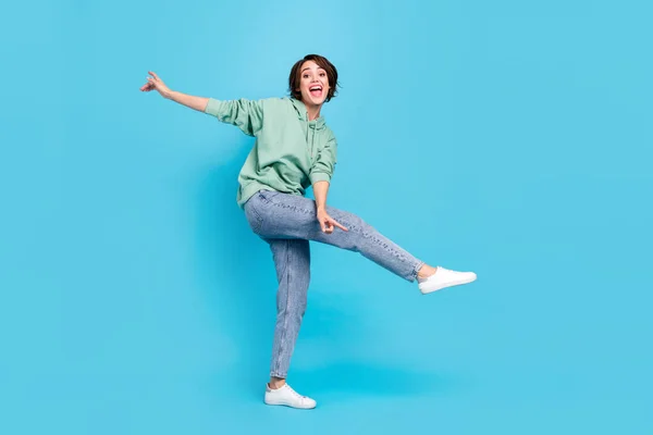 Volledige lichaam foto van koele jonge brunette dame dans slijtage pullover jeans schoenen geïsoleerd op blauwe achtergrond — Stockfoto