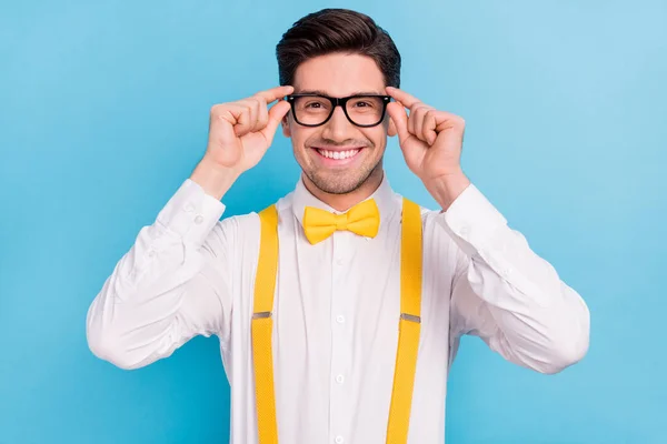 Foto de cara atraente doce usar suspensórios amarelos branco camisa braços óculos sorrindo isolado azul cor de fundo — Fotografia de Stock