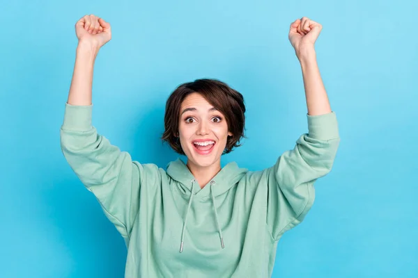 Фото блискучої щасливої жінки в зеленому светрі, що піднімається руками, кричить ізольований синій колір фону — стокове фото