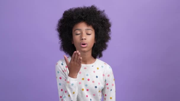 Charmant kind meisje sturen lucht kus hart verf geïsoleerde violette kleur achtergrond — Stockvideo