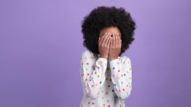 Terrifié gamin fille fermer couverture visage mains isolé pourpre couleur fond — Video