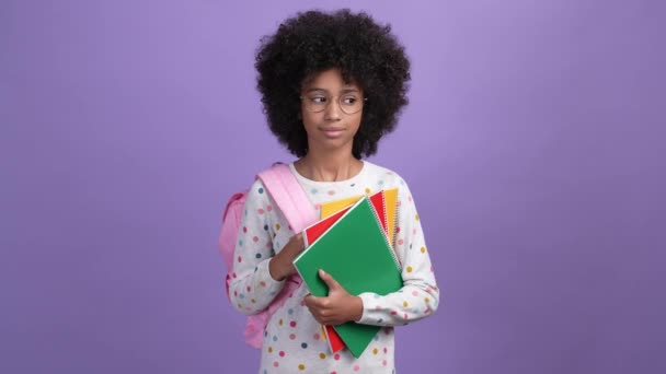 Inteligente niño académico mantenga mochila cuadernos aislado fondo de color vívido — Vídeo de stock