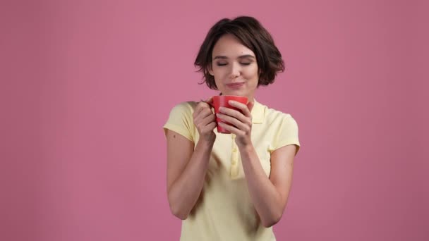 Позитивная леди держать капучино изолированный пастельный цвет фона — стоковое видео