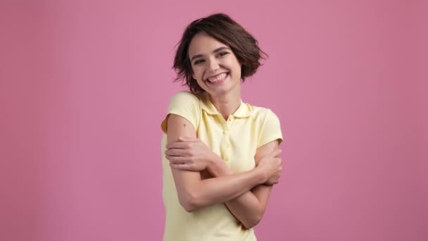 Positive fröhliche Dame umarmen sich selbst isoliert pastellfarbenen Hintergrund — Stockvideo