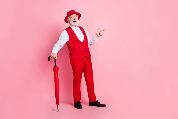 Ganzes Foto von gealterten Mann glücklich positives Lächeln halten Regenschirm Zeigefinger leer Raum ad promo isoliert über rosa Farbe Hintergrund — Stockfoto