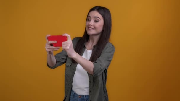 Jeune dame dispositif de jeu gagner poing jusqu'à isolé fond de couleur vibrante — Video