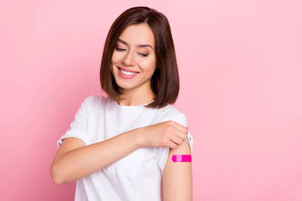 Retrato de chica sana alegre atractiva demostrando hombro anti sars mers cov pinchazo aislado sobre fondo de color pastel rosa —  Fotos de Stock