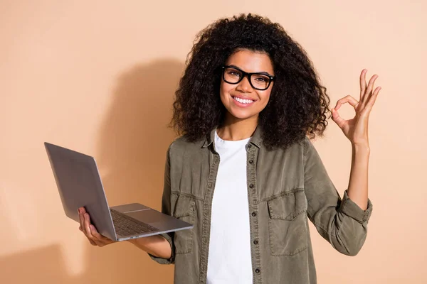 Foto de la mujer alegre juventud mostrar los dedos símbolo okey hecho anuncio aprobar gran portátil aislado sobre fondo de color beige — Foto de Stock