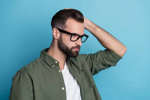 Profile photo of confident virile bearded guy hand hair look empty space wear green shirt isolated blue color background — Stock Photo, Image