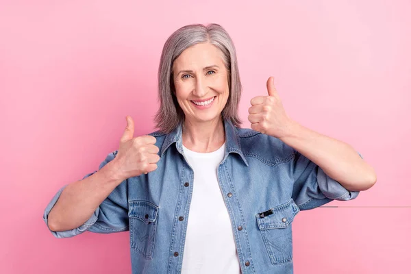 Foto der coolen alten Dame zeigen Daumen hoch tragen blaue Jacke isoliert auf pastellrosa Hintergrund — Stockfoto