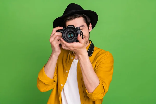 Foto de joven fotógrafo profesional guapo tomar la foto que la cámara aislada en el fondo de color verde — Foto de Stock