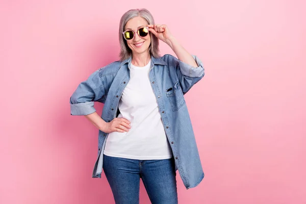 Foto do funky idosa senhora mão eyewear desgaste azul camisa branca camiseta isolada no fundo cor-de-rosa pastel — Fotografia de Stock