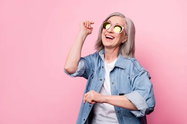 Foto av galen senior dam dans titta tomt utrymme bära glasögon blå skjorta isolerad på pastell rosa färg bakgrund — Stockfoto