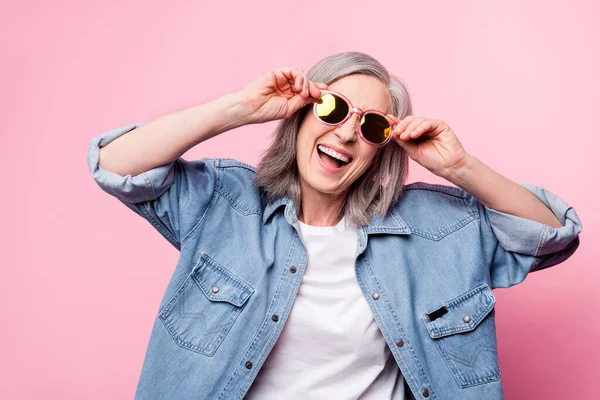 Foto di hooray invecchiato signora touch occhiali indossare giacca blu isolato su sfondo di colore rosa pastello — Foto Stock