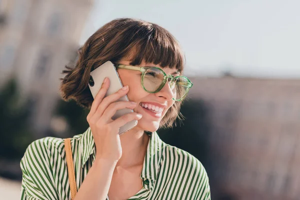 사교적 이고 사업적 인 여성 이 전화하는 사진은 대화하기 위해 안경 줄무늬 셔츠를 입고 도시 밖에 있는 — 스톡 사진