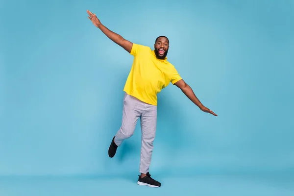 Foto de bonito adorável homem de pele escura usar amarelo t-shirt dança sorrindo isolado azul cor de fundo — Fotografia de Stock