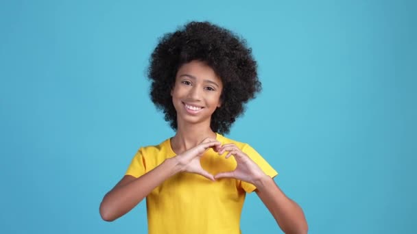 Linda niña hacer corazón manos símbolo aislado color azul fondo — Vídeos de Stock