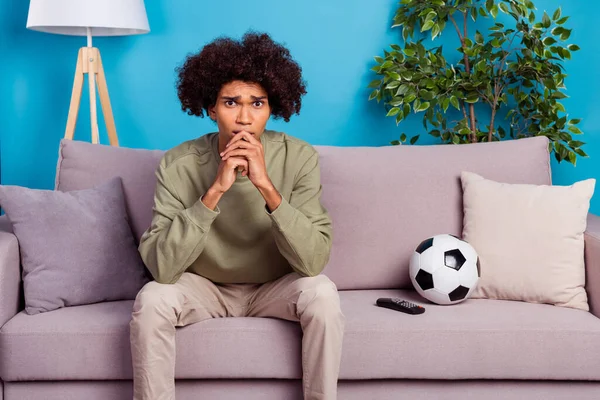 Photo of young guy anxious look tv soccer game play his favorite team sit divan isolated over blue color background — Stock Photo, Image