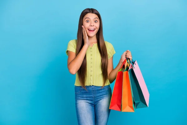 Fénykép izgatott vicces hölgy hold kiskereskedelmi csomagok wow arc kopás zöld felső elszigetelt kék háttér — Stock Fotó