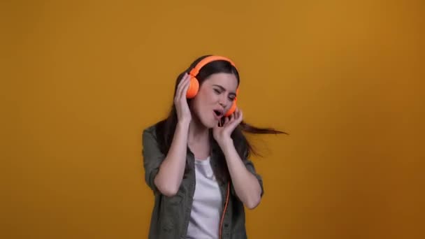 Lady kuulla kuulokkeet nauttia energinen melodia eristetty kirkas väri tausta — kuvapankkivideo